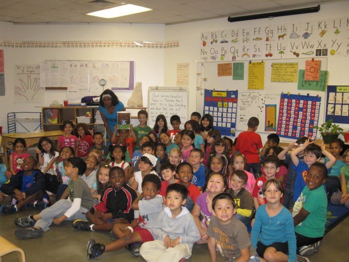 Dr. B in rear of photo (blue dress) talking with students after reading her book Mangoe and Marlie at University of Houston Charter school, Houston, TX.